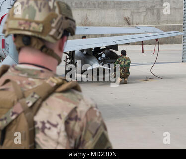 Un treno, consulenza, assistenza Command-Air advisor veglia su Afghan Air Force Afgani a caricare un-29 munizioni Marzo 6, 2018, Kabul Air Wing, Afghanistan. A differenza dei loro TAAC-aria omologhi, manutentori di AAF sono necessari per diventare qualificati in vari lavori tra cui: munizioni, armi e temporizzazione. (U.S. Air Force photo by Staff Sgt. Jared J. Duhon) Foto Stock