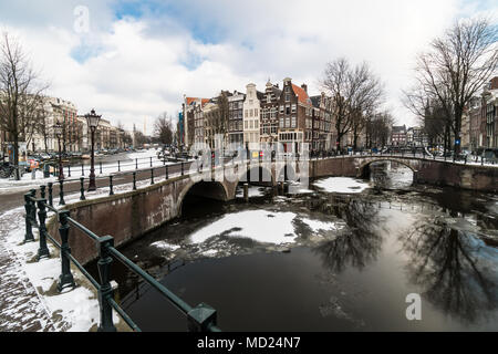 Splendida vista di Amsterdam canal congelati con neve durante l'ondata di freddo nel febbraio 2018 in un freddo giorno d'inverno. Foto Stock