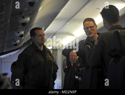 OAK HARBOR, nello Stato di Washington (Mar. 29, 2018) - Posteriore Adm. Michael Wettlaufer, medio, Commander, Carrier Strike Gruppo Tre, parla con la Cmdr. Nathan Gammache, sinistra, "Golden spadaccini' di Patrol Squadron (VP) 47 Executive Officer e marinai da VP-47 durante una visita di pattugliamento e ricognizione dieci ala. VP-47 è un Maritime Patrol Squadron di stanza a Naval Air Station Whidbey Island. Il 'Golden spadaccini' recentemente completato il loro primo mille ore di volo in P-8A Poseidone, la Marina's premiere long-range anti-sommergibile warfare piattaforma. Foto Stock