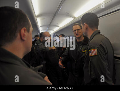 OAK HARBOR, nello Stato di Washington (Mar. 29, 2018) - Posteriore Adm. Michael Wettlaufer, centro a destra, Commander, Carrier Strike Gruppo Tre, parla con Aircrewman (l'operatore) 1a classe Kyle Olson, destro attaccato al 'Golden spadaccini' di Patrol Squadron (VP) 47, durante una visita di pattugliamento e ricognizione dieci ala. VP-47 è un Maritime Patrol Squadron di stanza a Naval Air Station Whidbey Island. Il 'Golden spadaccini' recentemente completato il loro primo mille ore di volo in P-8A Poseidone, la Marina's premiere long-range anti-sommergibile warfare piattaforma. Foto Stock