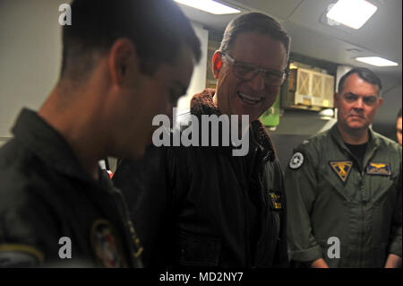 OAK HARBOR, nello Stato di Washington (Mar. 29, 2018) - Posteriore Adm. Michael Wettlaufer, medio, Commander, Carrier Strike Gruppo Tre, parla con Aircrewman (l'operatore) 2a classe Tyler Willsey, sinistra, attaccato al 'Golden spadaccini' di Patrol Squadron (VP) 47, durante una visita di pattugliamento e ricognizione dieci ala. VP-47 è un Maritime Patrol Squadron di stanza a Naval Air Station Whidbey Island. Il 'Golden spadaccini' recentemente completato il loro primo mille ore di volo in P-8A Poseidone, la Marina's premiere long-range anti-sommergibile warfare piattaforma. Foto Stock