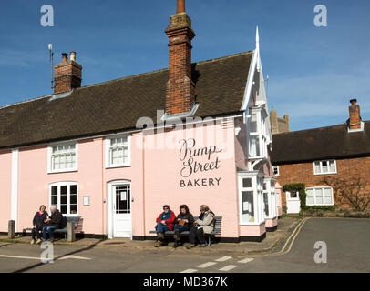 Le persone al di fuori seduta sulla soleggiata giornata invernale Strada della pompa panificio, Orford, Suffolk, Inghilterra, Regno Unito Foto Stock