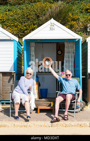 Bournemouth Dorset, Regno Unito. Il 18 aprile 2018. Regno Unito: meteo bella calda giornata di sole a Bournemouth spiagge con cielo azzurro e sole ininterrotta, come i visitatori in testa al mare per godere il giorno più caldo dell'anno finora. Giovane contento di vedere il sole fuori come essi relax da loro Beach Hut. Mini ondata di caldo. Credito: Carolyn Jenkins/Alamy Live News Credito: Carolyn Jenkins/Alamy Live News Foto Stock