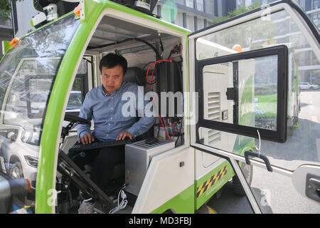 Shanghai, Cina. Xviii Apr, 2018. Un personale esegue il debug di un driverless spazzatrice a Shanghai in Cina orientale, Aprile 18, 2018. Due driverless spazzatrici stradali sono stati impiegati per la prova in Shanghai Tus-Caohejing Science Park di recente. Credito: Ding Ting/Xinhua/Alamy Live News Foto Stock