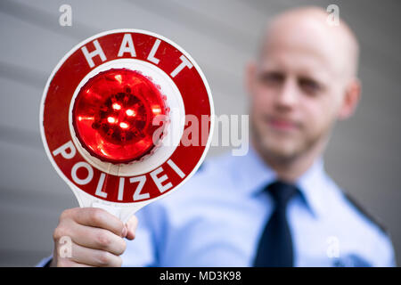 18 aprile 2018, Germania, Moenchengladbach: un ufficiale di polizia può contenere fino a fermo di polizia della lettura del segno 'Halt Polizei" (lit. Fermata della polizia) durante un evento stampa. Foto: Marius Becker/dpa Foto Stock