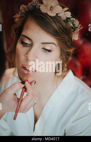 Sposa avente lipliner applicato da make-up artist Foto Stock