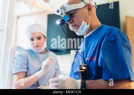 Dentista indossando dentale loupes binocolo Foto Stock