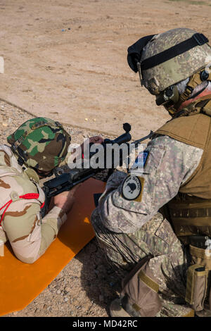 Una nuova Zelanda Defence Force Stati, con la Task Force Taji, assiste un soldato iracheno assegnato a 74a Brigata con attrazioni regola su un M40 bullone-azione fucile da cecchino durante l'azzeramento della porzione di precisione di tiro avanzato della formazione di Camp Taji, Iraq, Marzo 18, 2018. Camp Taji è una Combined Joint Task Force - Funzionamento inerenti risolvere migliorata capacità del partner location dedicate alla formazione delle forze di partner e di migliorare la loro efficacia. (U.S. Esercito foto di Spc. Audrey Ward) Foto Stock