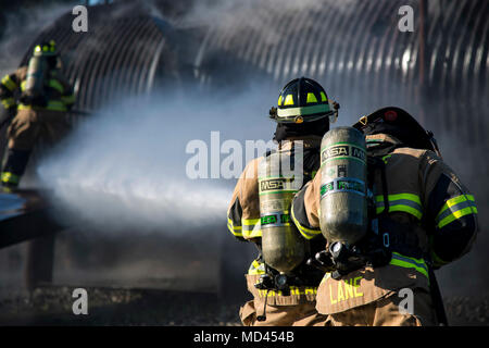 Senior Airman Justin Lane, destra e Staff Sgt. Tyler McFarland, 23d' ingegnere civile Squadron (CES) vigili del fuoco, lavorano insieme per spegnere un incendio su un simulatore di aeromobile durante un live-fuoco bruci esercizio, Marzo 15, 2018 a Moody Air Force Base, Ga. I vigili del fuoco dalla 23d CES condotta l'esercizio per dimostrare il velivolo di soccorso le capacità di estinzione per i leader della comunità e Moody's comandanti onorario. (U.S. Air Force foto di Airman 1. Classe Erick Requadt) Foto Stock