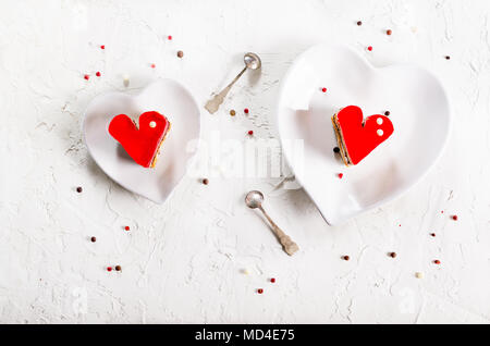 Due jelly heart-shaped torte su cemento bianco sullo sfondo. Spazio libero per il testo Foto Stock