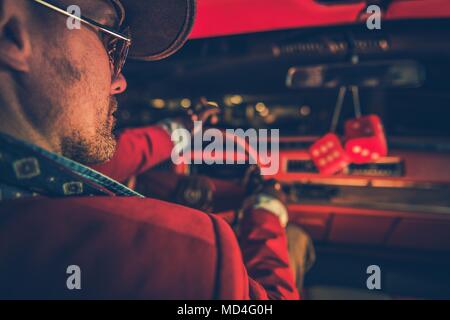 American Classic Car Ride in stile. Uomini caucasici Western usura sulla trasmissione di notte. Foto Stock