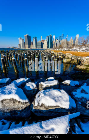 Inferiore dello skyline di Manhattan panorama in nevoso inverno tempo dal ponte di Brooklyn Park riverbank, New York City, Stati Uniti d'America Foto Stock