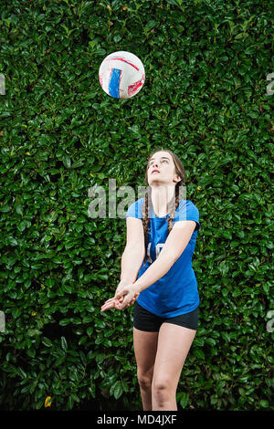 Una ragazza adolescente (13 anni) l'impostazione di un campo di pallavolo. Foto Stock