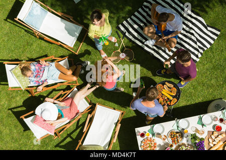 Amici avente un barbecue party durante i momenti di relax all'ombra Foto Stock