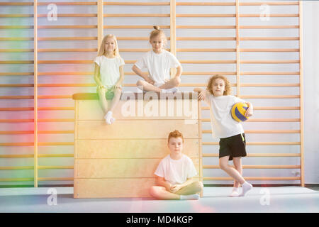 I ragazzi che posano per una foto accanto ad un cavallo di vaulting in palestra Foto Stock