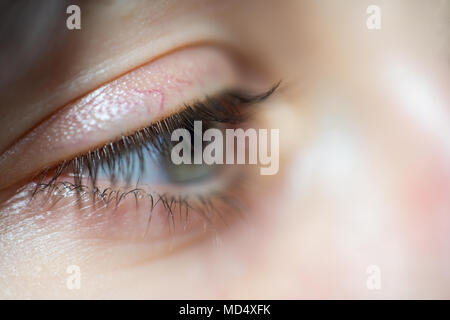 In primo piano della donna con occhi blu e le ciglia lunghe che guarda lontano nella tristezza Foto Stock