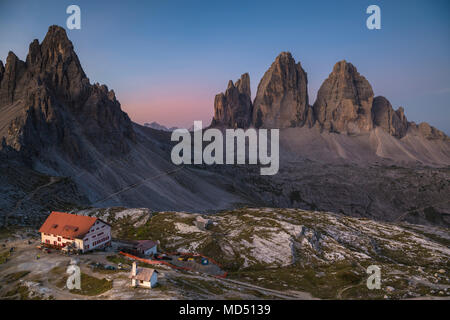 Tre Cime di Lavaredo e Dreizinnen capanna a sunrise, Tre Cime del Parco Naturale delle Dolomiti, Alto Adige, Italia Foto Stock