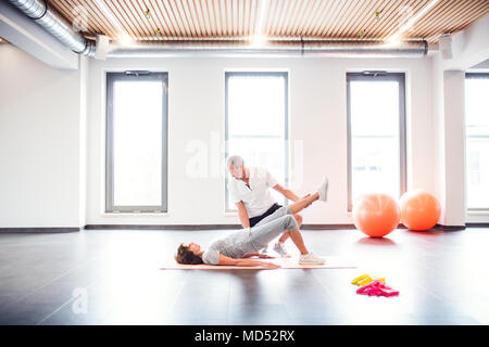 Senior fisioterapista lavora con un paziente femmina. Foto Stock