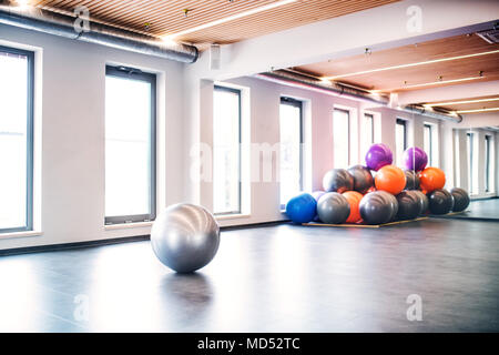 Giovane donna facendo esercizio con una fitball in una palestra. Foto Stock