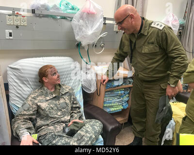 Sgt. Shanda Owens, un patriota di controllo antincendio Enhanced Operator/Maintainer assegnato al Delta batteria, 5° Battaglione, settima la difesa aerea artiglieria, decimo esercito aria e la difesa missilistica comando viene controllato dal colonnello israeliano Moshe Meyouhass, un medico assegnato all'unità Yakar, Soroka Medical Center dopo un giunto evacuazione medica (MEDEVAC) missione di formazione ed evacuazione medica durante un Juniper Cobra 18 nel deserto del Negev Mar 7, 2018. Foto Stock