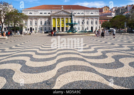 Lisbona, Portogallo - 25 giugno 2016: piazza Rossio con la sua tradizionale onde del bianco e nero Pavimentazione mosaico in stile barocco fontana in bronzo e compit Foto Stock