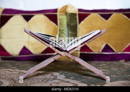 Aprire il corano appoggiato su un libro tradizionale titolare. - Rehan. Nizwa, Oman. Foto Stock