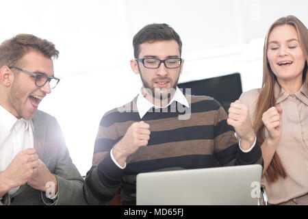 Tre dipendenti eccitati ricevendo buone notizie insieme sulla linea Foto Stock