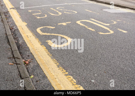 Fermata bus marcature dipinta su una strada asfaltata in Poole, Dorset, Regno Unito Foto Stock