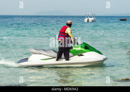 L'uomo il salvataggio su un motociclo di acqua sul mare. unidentified maschio nero vista da dietro. Oceano indiano, il mare delle Andamane Foto Stock