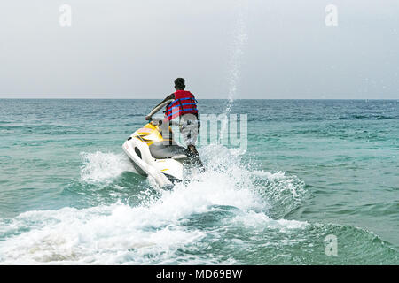 L'uomo il salvataggio su un motociclo di acqua sul mare. unidentified maschio nero vista da dietro. Oceano indiano, il mare delle Andamane Foto Stock