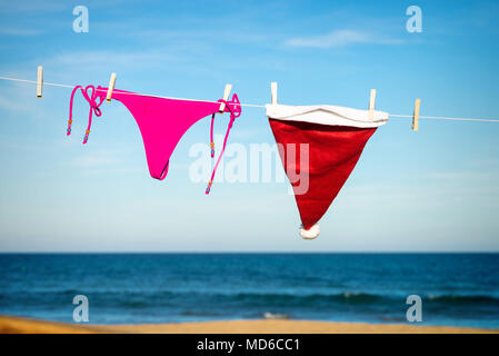 Tanga Bikini e Santa hat essiccazione su una spiaggia soleggiata, una fuga stagionale concept Foto Stock