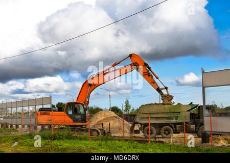 Benna di un escavatore di carichi pesanti con il terreno per la costruzione della strada ad alta velocità intorno Krasnoe Selo. Industria pesante Macchinari per excavatio Foto Stock