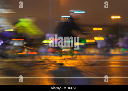 Movimento immagine sfocata di cavalcare i ciclisti. Sfilata di ciclisti in città, notte, astratta. Moderno stile di vita attivo, uno stile di vita sano concetto Foto Stock