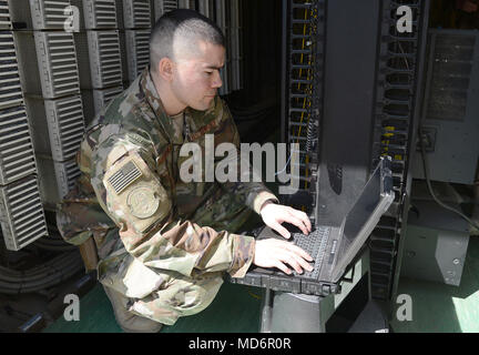 Il personale Sgt. Brandon Hasegawa, 455th comunicazione Expeditionary Squadron cyber tecnico di trasporto, attiva una porta di rete Mar. 22, 2018 a Bagram Airfield, Afghanistan. Oltre a mantenere e gestire la rete, Hasegawa rimane occupato trattare con problemi di vulnerabilità, il test e la risoluzione dei problemi dei sistemi in rete apparecchiature nonché le attivazioni di porta. (U.S. Air Force photo by Staff Sgt. La divina Cox) Foto Stock