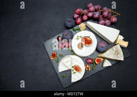 Formaggio Camembert e tagliare una fetta su pietra che serve board Foto Stock