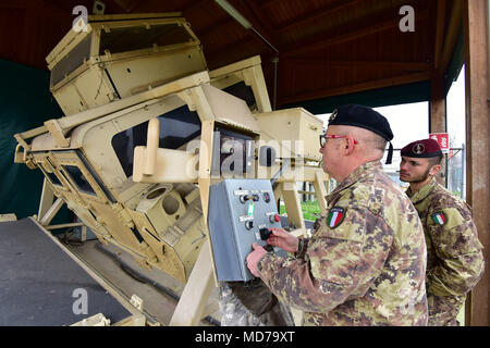 Sgt. Il Mag. Gaetano Massimo Giordano esercito italiano, assiste l'Esercito Italiano paracadutisti assegnato al reggimento "Savoia Cavalleria" Folgore Brigata Grosseto, durante il training con elevata mobilità multiuso di veicolo su ruote (HMMWV) assistenza egress trainer (calore), a Caserma Ederle Vicenza, Italia, 29 marzo 2018. Il simulatore consente ai soldati di pratica uscire dai veicoli, di competenze e di impegnarsi in scenari realistici. I paracadutisti italiani utilizzare U.S. RTSD esercito sud attrezzatura per migliorare le relazioni bilaterali e per espandere i livelli di cooperazione e la capacità del personale coinvolto in joint operatio Foto Stock