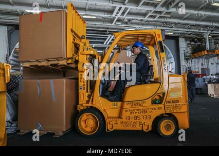 180329-N-YP246-031 OCEANO ATLANTICO (29 marzo 2018) Lo specialista della logistica di terza classe Jon Ventura trasporta le forniture in hangar bay a bordo della Nimitz-class portaerei USS Abraham Lincoln (CVN 72). (U.S. Foto di Marina di Massa Specialista comunicazione marinaio Darcy McAtee/rilasciato) Foto Stock