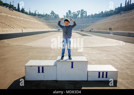 Ragazzo in posa sul podio del vincitore a Panathinaiko Stadium, Atene, Grecia, Europa Foto Stock