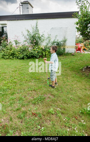 Little Boy giocare in giardino Foto Stock