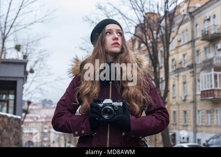 Hipster ragazza viaggiatore con retro fotocamera per scattare delle foto a camminare su una strada di città Foto Stock