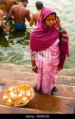 Una donna con il suo cesto di diya lampade per la vendita Foto Stock