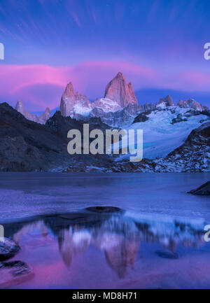 Fitz Roy montagne di sunrise con bagliore di montagna e riflessioni sulla metà lago ghiacciato nei pressi di El Chalten in Patagonia Argentina Foto Stock