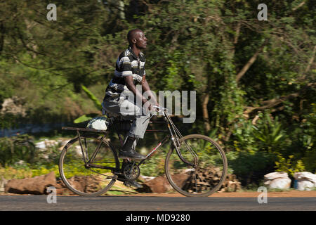 Un ciclista cavalca un roadster tradizionale stile di bicicletta, comunemente chiamato "Black Mamba' in Africa orientale. Anche se sono ancora una visione comune, essi Foto Stock