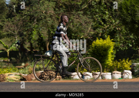 Un ciclista cavalca un roadster tradizionale stile di bicicletta, comunemente chiamato "Black Mamba' in Africa orientale. Anche se sono ancora una visione comune, essi Foto Stock