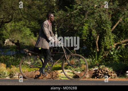 Un ciclista cavalca un roadster tradizionale stile di bicicletta, comunemente chiamato "Black Mamba' in Africa orientale. Anche se sono ancora una visione comune, essi Foto Stock