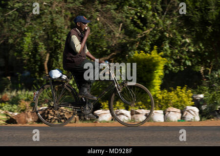 Un ciclista cavalca un roadster tradizionale stile di bicicletta, comunemente chiamato "Black Mamba' in Africa orientale. Anche se sono ancora una visione comune, essi Foto Stock