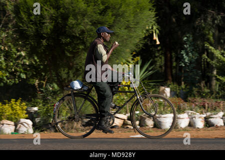 Un ciclista cavalca un roadster tradizionale stile di bicicletta, comunemente chiamato "Black Mamba' in Africa orientale. Anche se sono ancora una visione comune, essi Foto Stock