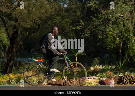 Un ciclista cavalca un roadster tradizionale stile di bicicletta, comunemente chiamato "Black Mamba' in Africa orientale. Anche se sono ancora una visione comune, essi Foto Stock