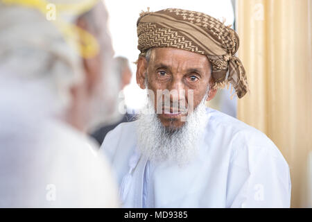 Nizwa, Oman - 23 Mar 2018: Ritratto di un anziano uomo Omani partecipando ad una asta di capra su un venerdì mattina mercato di capra. Foto Stock