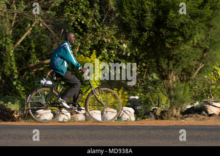 Un ciclista cavalca un roadster tradizionale stile di bicicletta, comunemente chiamato "Black Mamba' in Africa orientale. Anche se sono ancora una visione comune, essi Foto Stock